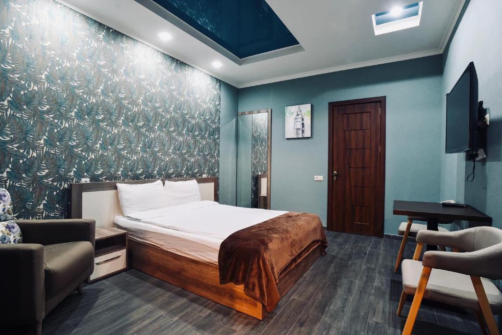 a bedroom with a bed and a couch and a desk at 7 Rooms Hotel in Tserovani