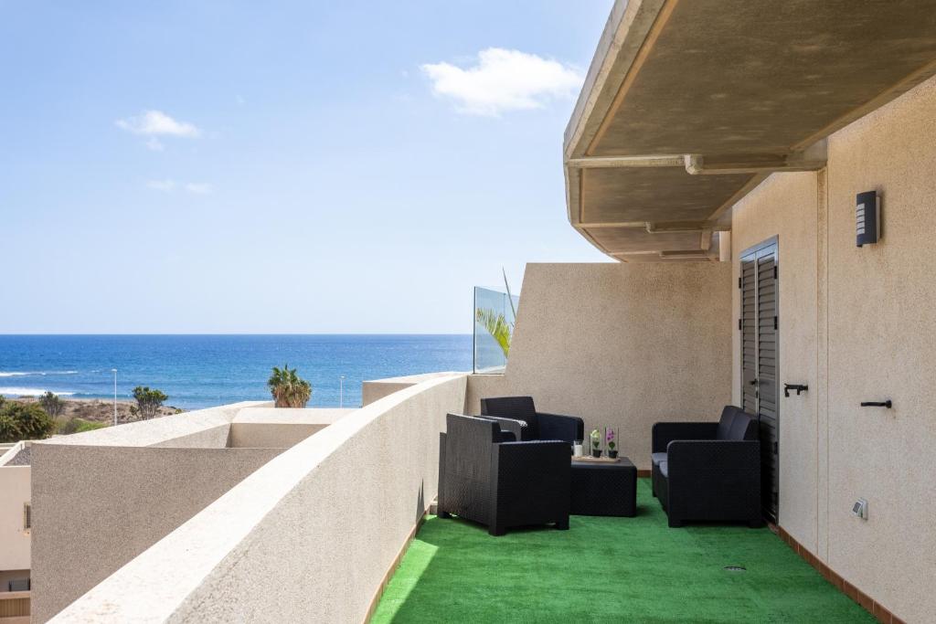 a balcony with chairs and a view of the ocean at River Vista Marina in El Médano