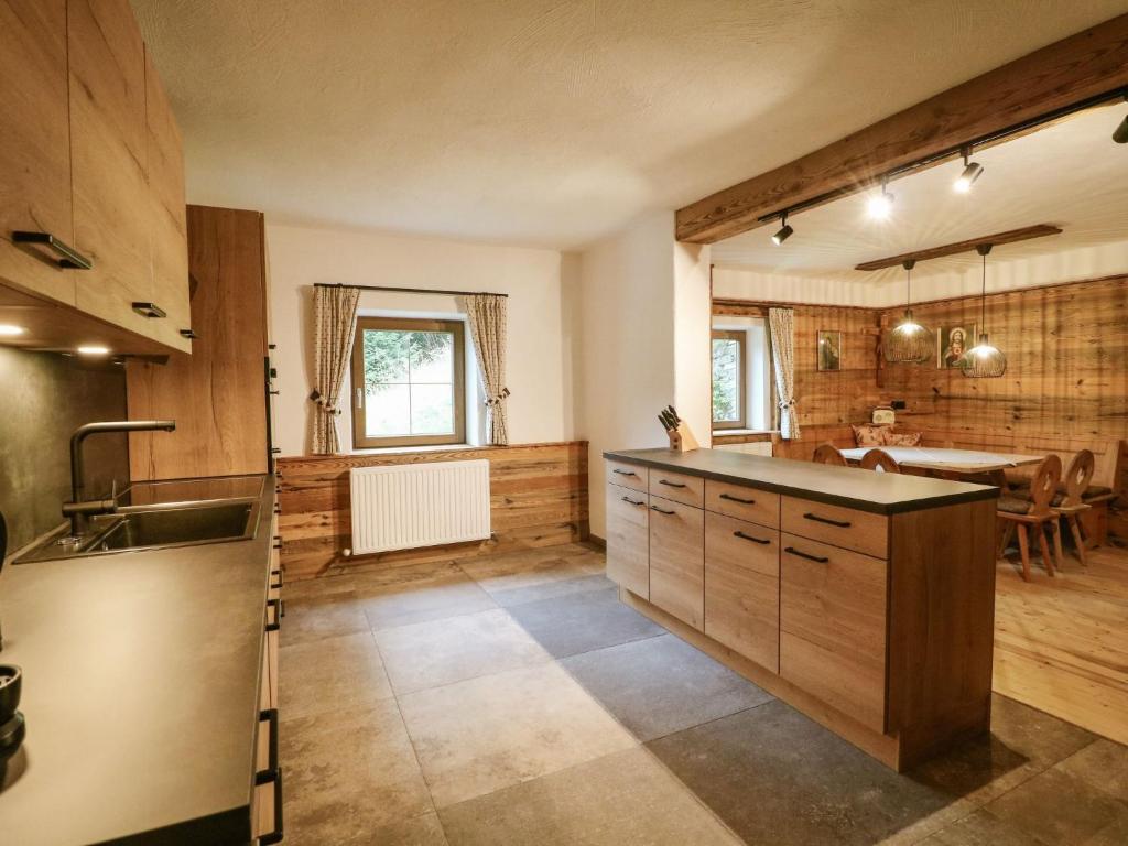 a large kitchen with wooden cabinets and a table at Holiday Home bergGLÜCK by Interhome in Spiss