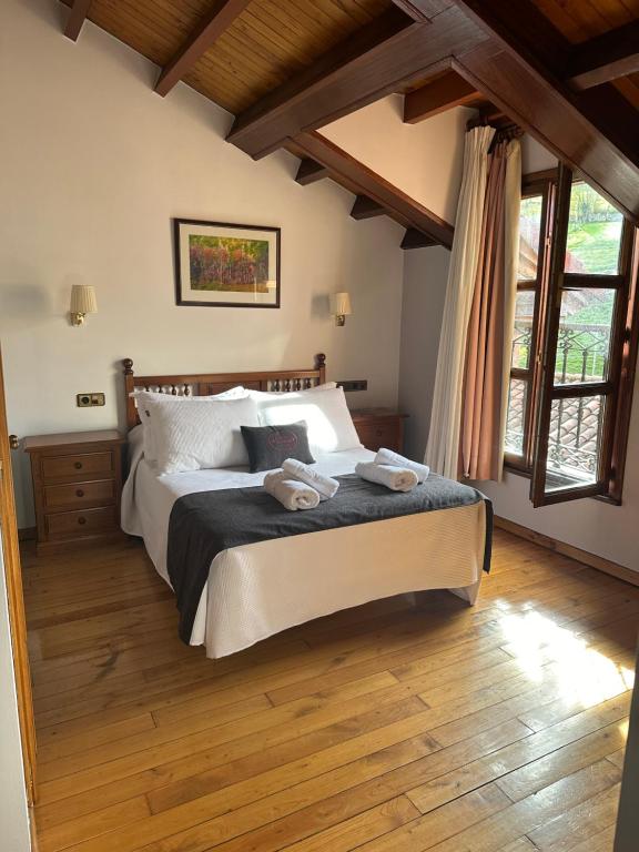 a bedroom with a large bed and wooden floors at Pensión Casa Morán in Benia de Onís