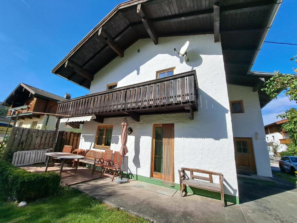 a white house with a balcony and a table at Holiday Home Haus Broda by Interhome in Achenkirch