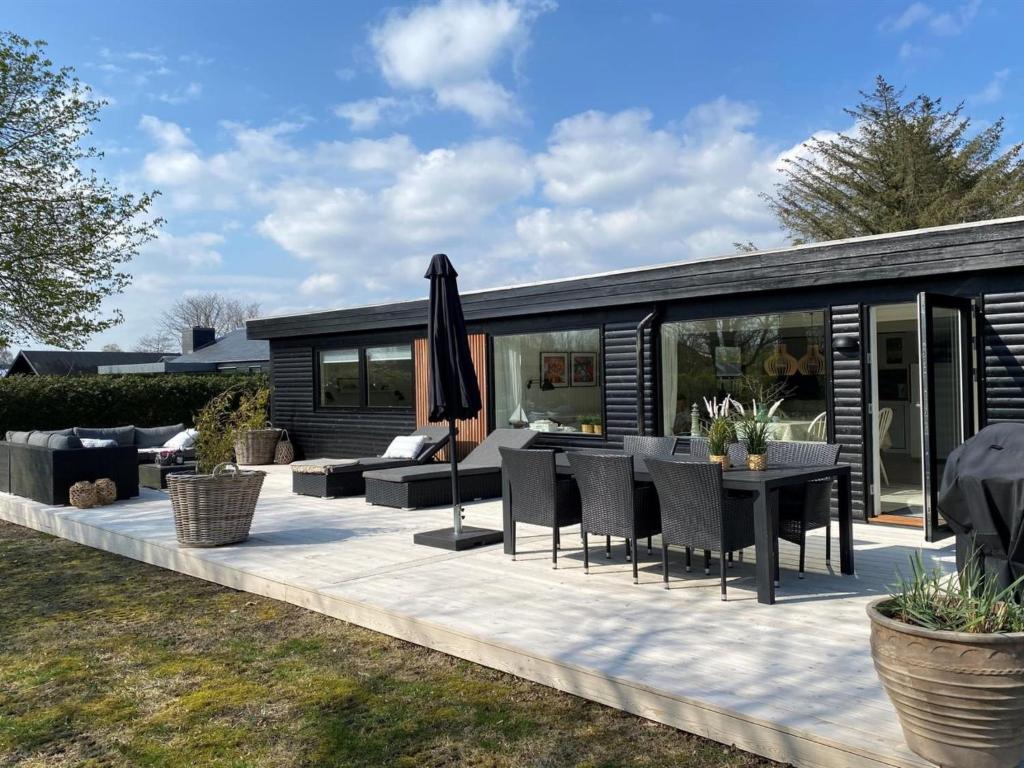 un patio al aire libre con mesa y sillas en Holiday Home Elma - 350m from the sea in SE Jutland by Interhome en Juelsminde