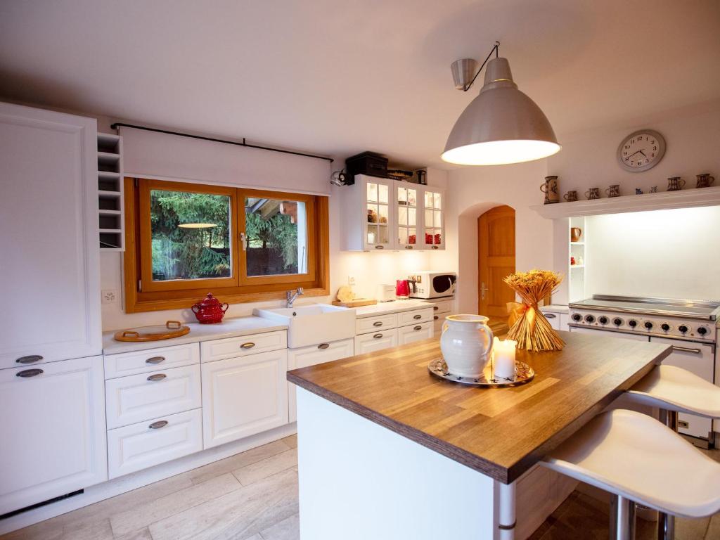 a kitchen with white cabinets and a wooden table at Chalet Chalet Le Haut Pré by Interhome in Villars-sur-Ollon