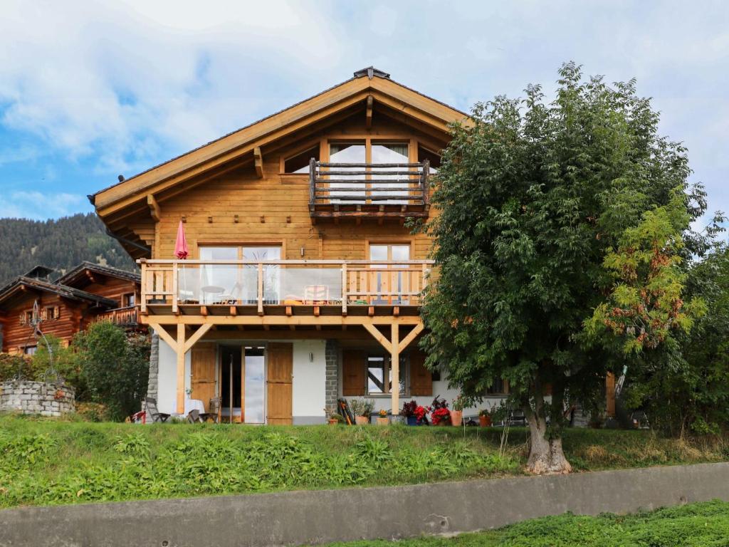 une maison en bois avec un balcon et un arbre dans l'établissement Chalet Chalet Picoulet by Interhome, à Villars-sur-Ollon