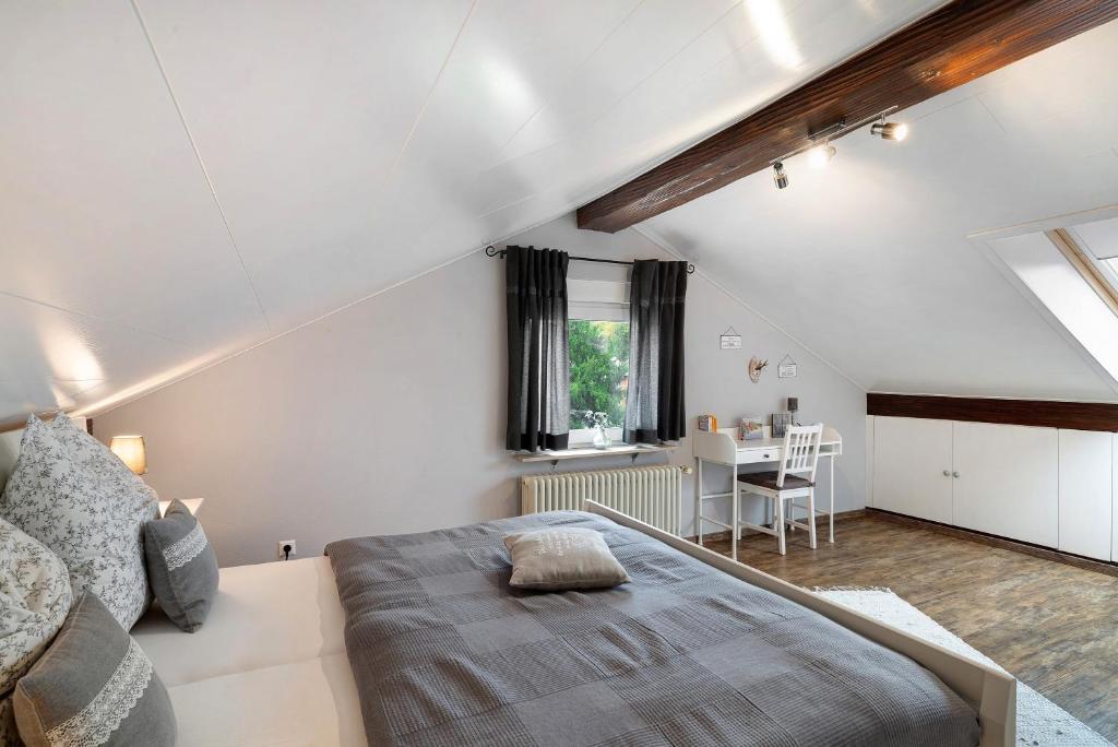 a attic bedroom with a bed and a table at Schwarzwaldtani - Dörfle in Ottersweier