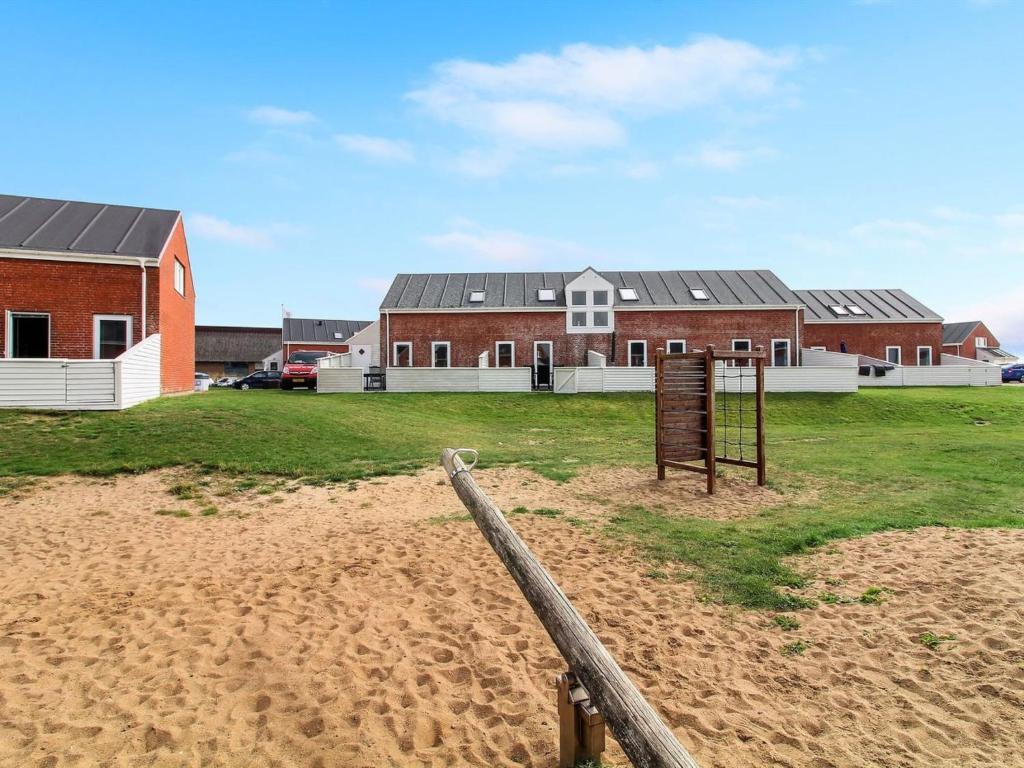 a building with a fence in the middle of a field at Apartment Ilka - all inclusive - 2-3km from the sea by Interhome in Sønderby