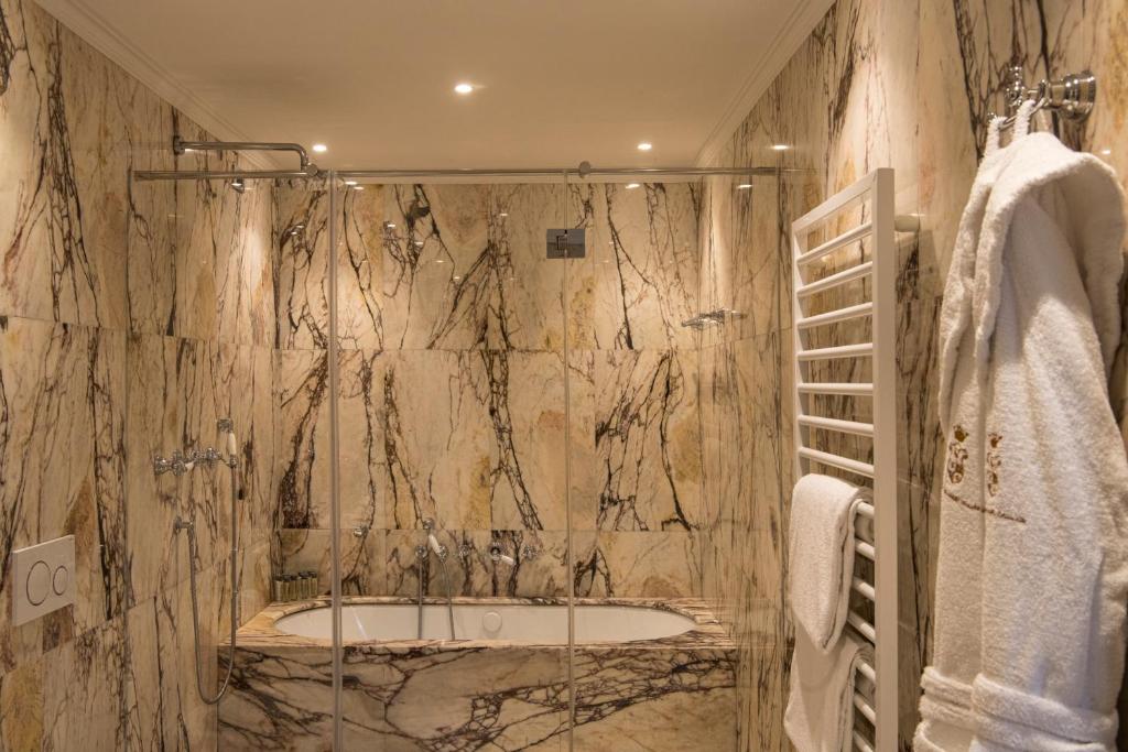 a bathroom with a shower and a bath tub at Hotel Nani Mocenigo Palace in Venice