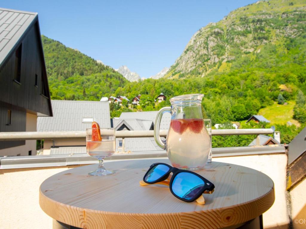 - une boisson et des lunettes de soleil sur une table sur un balcon dans l'établissement Apartment Les Hameaux de la Perrière-2 by Interhome, à Saint-Colomban-des-Villards