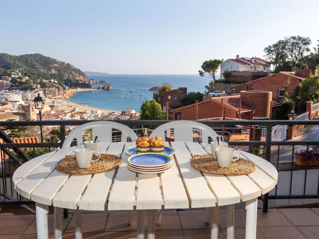 a table with a plate of food on a balcony at Apartment Codolar by Interhome in Tossa de Mar