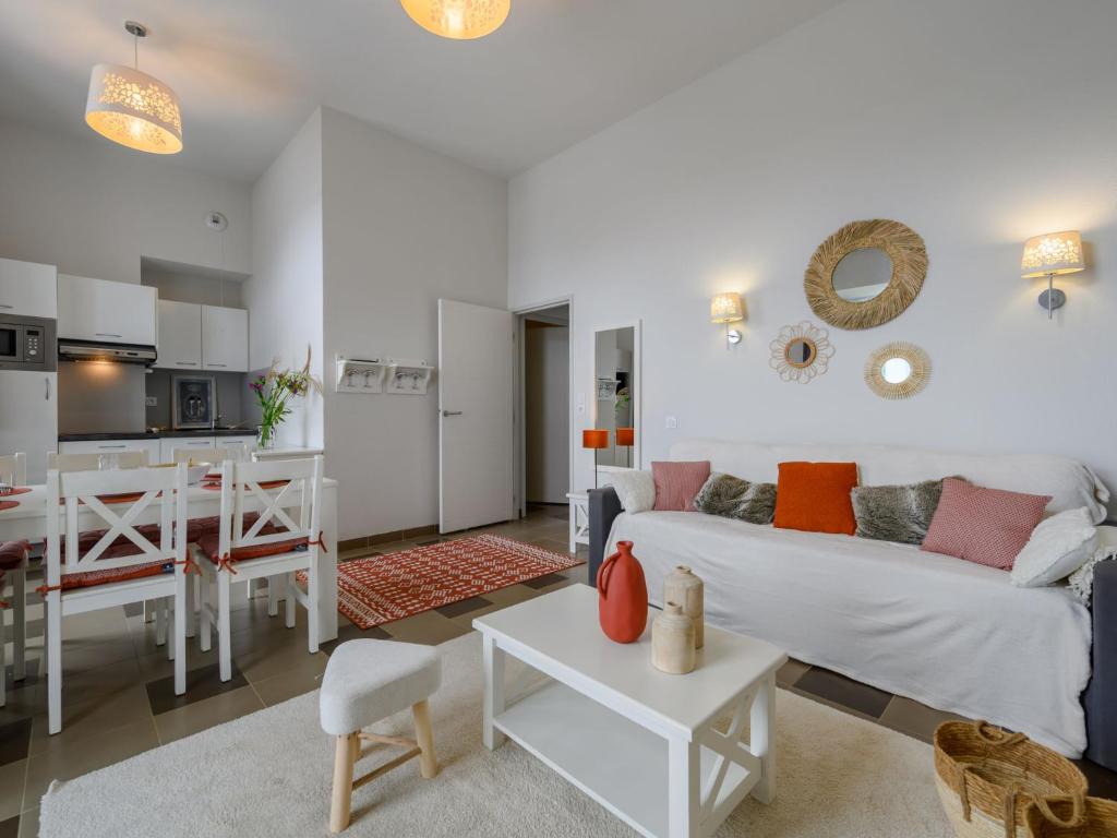 een woonkamer en een keuken met een bank en een tafel bij Apartment Le Château de Kergonano-9 by Interhome in Baden