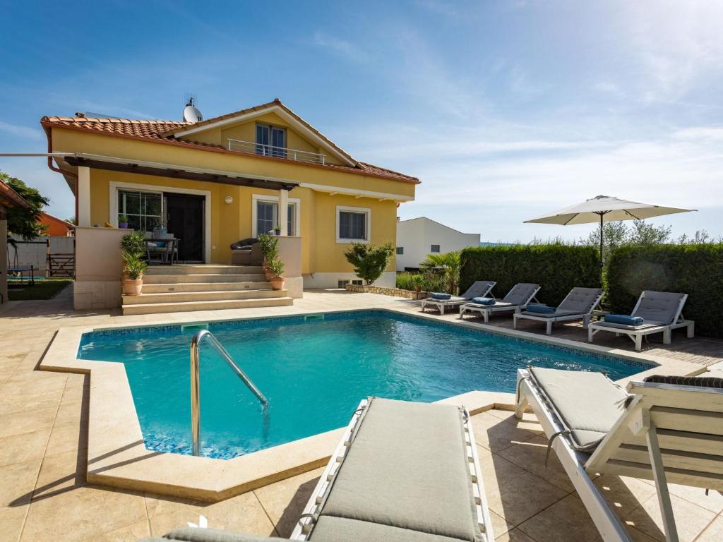 uma piscina com cadeiras e uma casa em Holiday Home Villa Krase by Interhome em Krnica