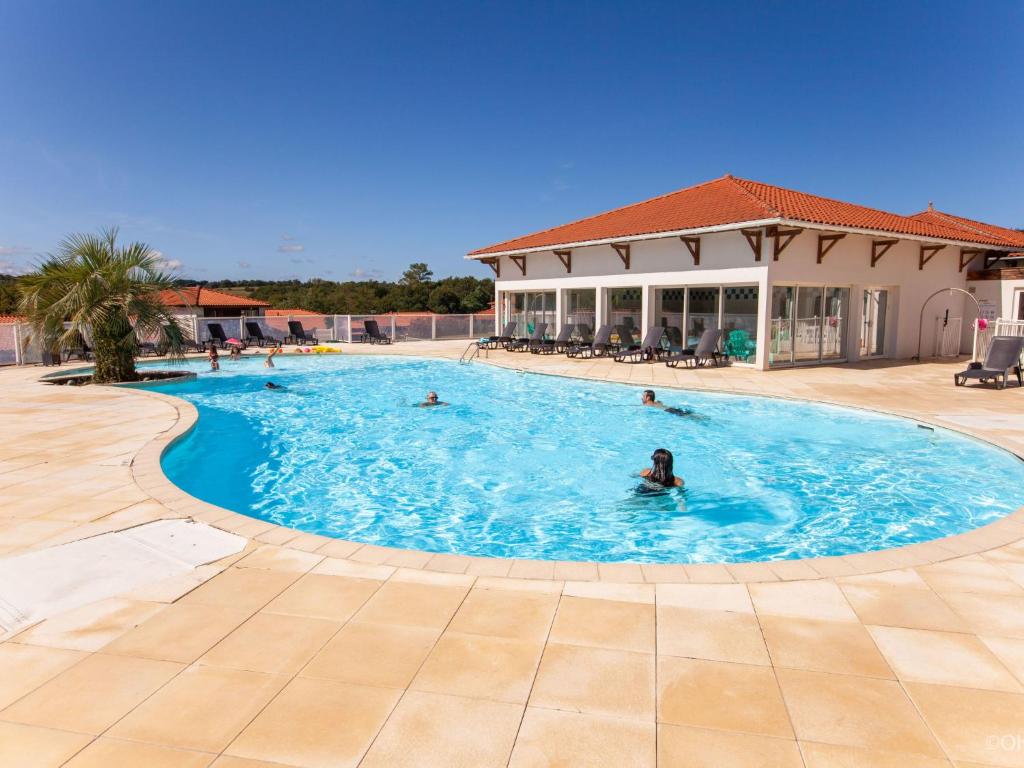 un groupe de personnes nageant dans une piscine dans l'établissement Apartment Les Hameaux de La Chalosse-1 by Interhome, à Cassen