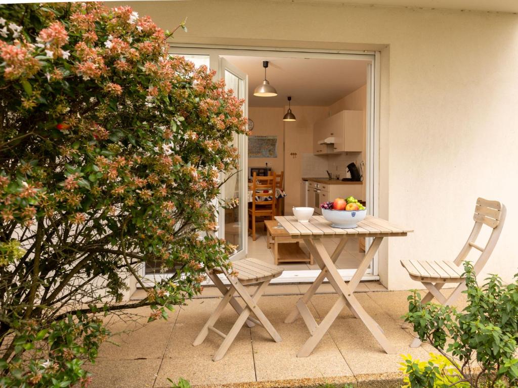 - une table et des chaises sur une terrasse avec un bol de fruits dans l'établissement Apartment L'air du Large by Interhome, à Saint-Malo