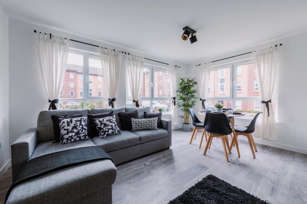 a living room with a couch and a table at RelaxingSleep Apartments in Glasgow