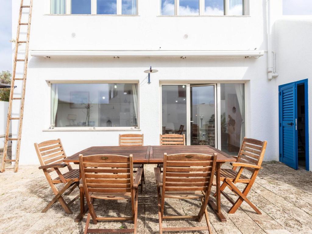 uma mesa de madeira e cadeiras em frente a uma casa branca em Holiday Home Pisa 2 by Interhome em Torre Vado