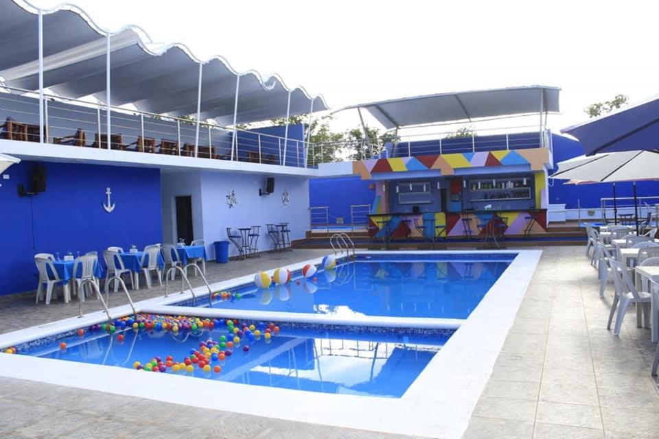 una gran piscina con sillas y mesas y un edificio en OceanSide Hotel & Pool, en Bayahibe