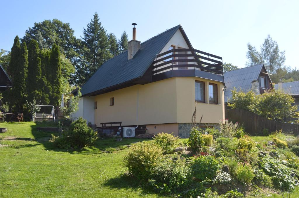 uma casa com um telhado preto num quintal em Chata Olomouc Tovéř 