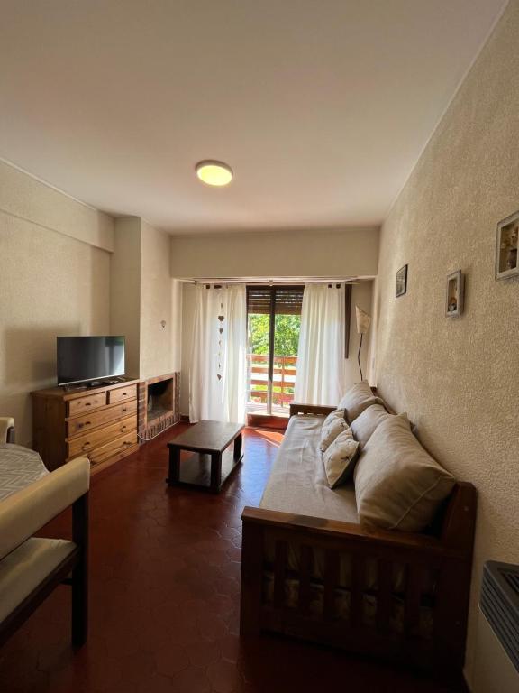 a living room with a bed and a television at Pinamar departamento in Pinamar