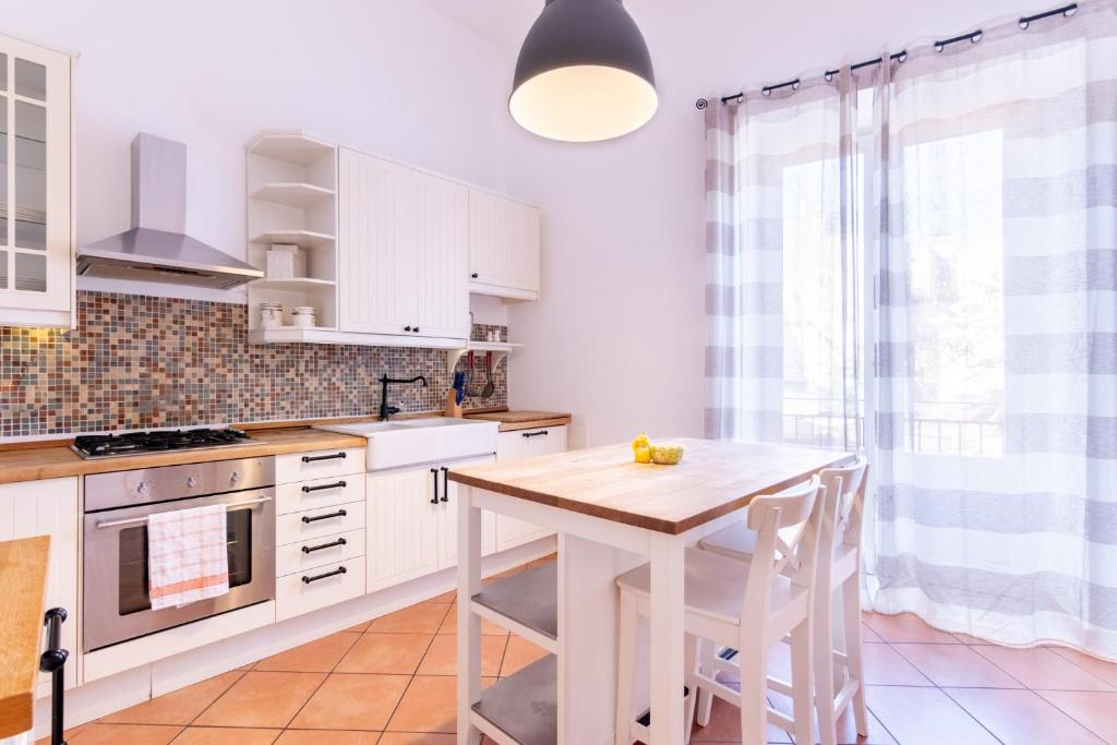 cocina con armarios blancos y mesa de madera en Viola's Luxury House en Palermo