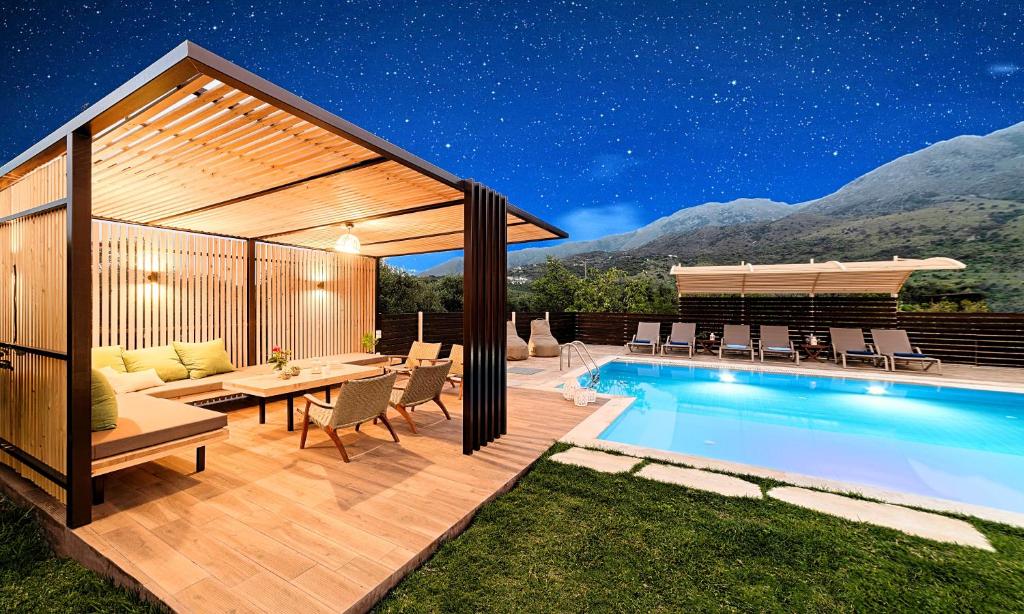 a backyard with a swimming pool and a pavilion at Cretan Sunrise Villa Heated Pool in Dhimitroulianá