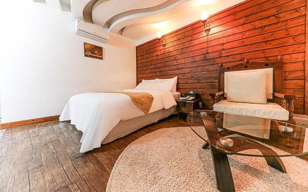 sypialnia z łóżkiem i szklanym stołem w obiekcie Cheonan Business Hotel w mieście Cheonan