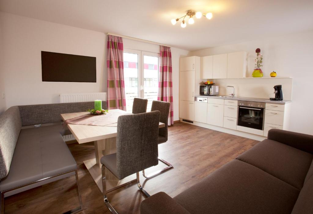 a kitchen and living room with a table and chairs at Appartements Luna by Schladming-Appartements in Schladming