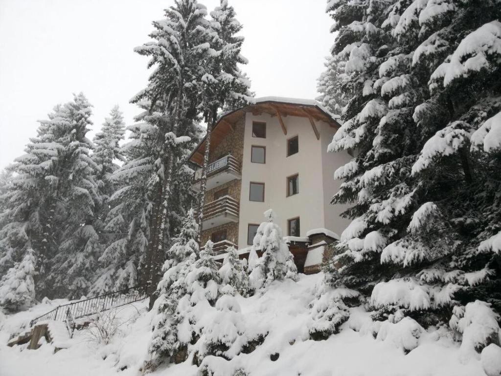 um edifício na neve ao lado de algumas árvores em Apartments Planinski raj em Travnik