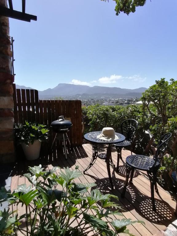 努尔德霍克African Violet Guest Suites的露台上的一张桌子和几把椅子，可以欣赏美景