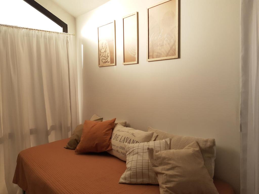 een slaapkamer met een bed met kussens erop bij Casa a estrenar! A 5 minutos de la terminal de omnibus y muy cerca del centro! in El Calafate
