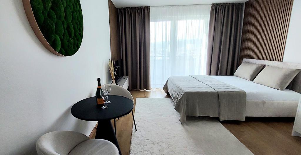 um quarto com uma cama, uma mesa e uma janela em Apartmán SoHo s private parking, 5 min peso do centra em Košice