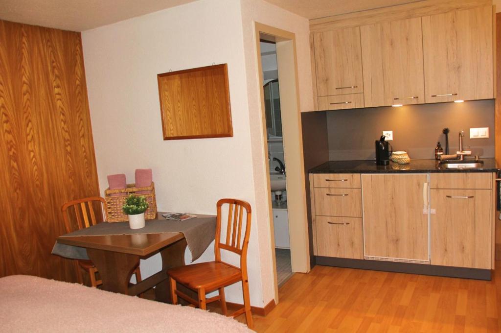 a small kitchen with a table and a table and chairs at 5Min Walk To Audi FIS Ski World Cup Swiss Studio in Adelboden