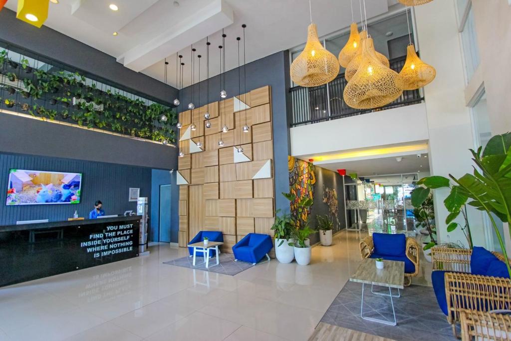 a lobby with blue chairs and a reception desk at Hotel FortunaGrande Seturan Yogyakarta in Yogyakarta