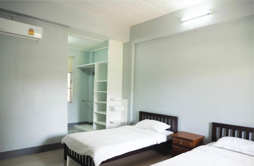 a bedroom with two beds and a closet at PJ PLACE in Chiang Rai