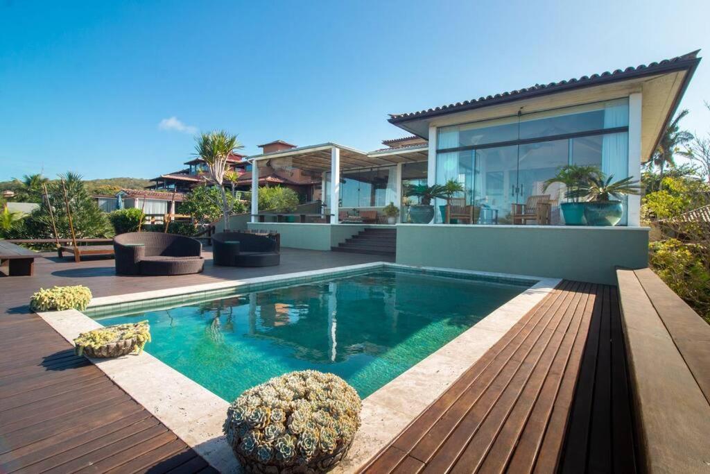 a swimming pool in front of a house at Mansão Imponente com Seis Suítes a 1min das Areias Praia da Ferradura Por Luxury Rentals in Búzios