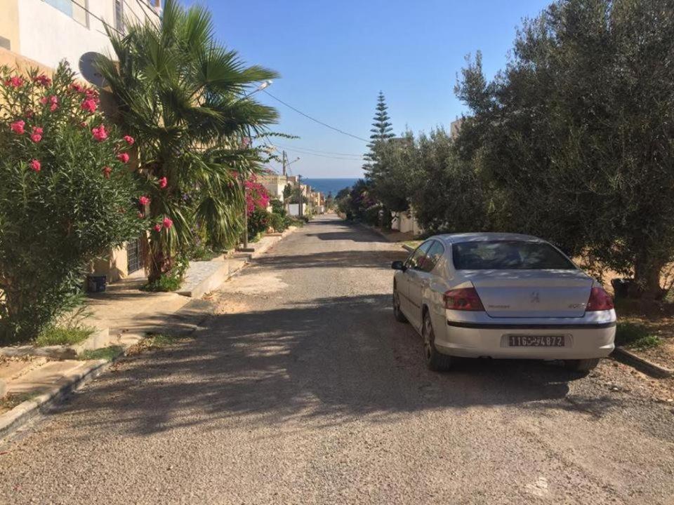 ein weißes Auto, das am Straßenrand geparkt ist in der Unterkunft maison d'hôte familiale للعائلات فقط in Sousse