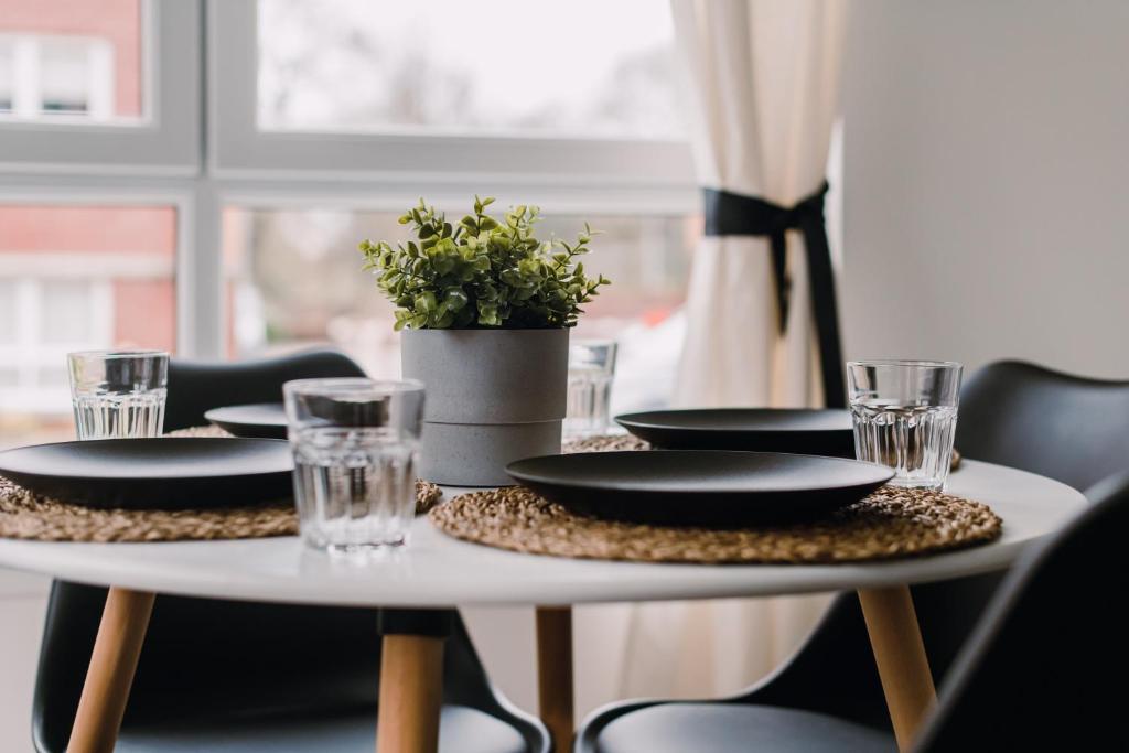 a table with plates and glasses on top of it at ComfySleep Apartments in Glasgow