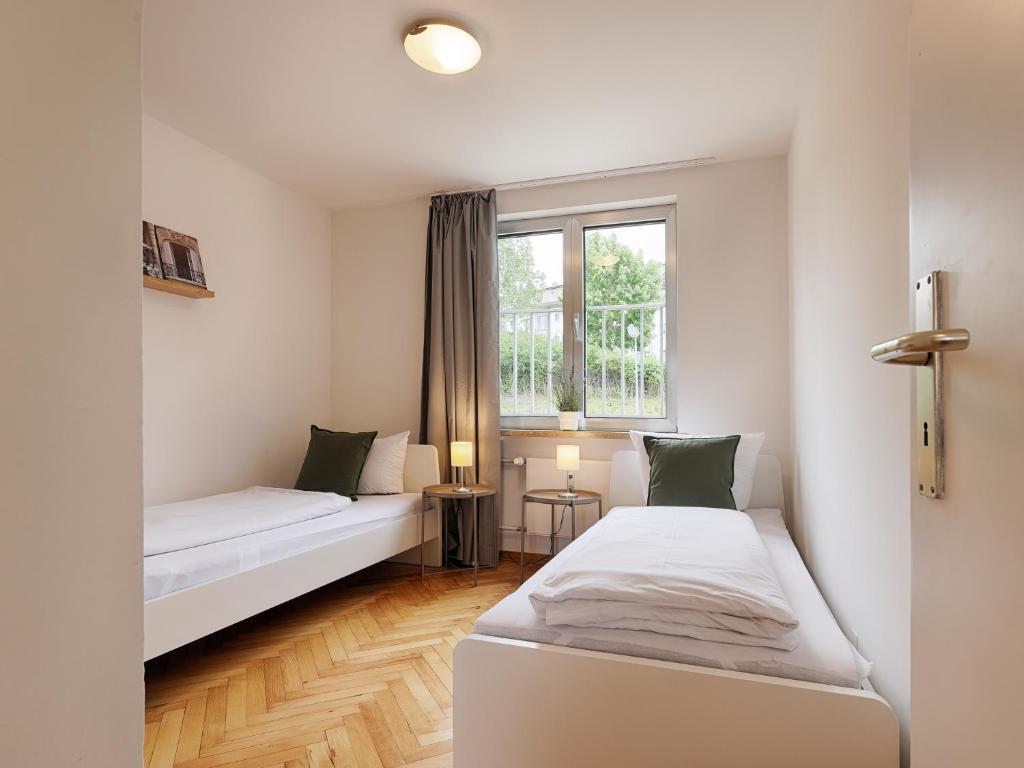 基青根的住宿－Apartmenthaus Kitzingen - großzügige Wohnungen für je 4-8 Personen mit Balkon，客房设有两张床和窗户。