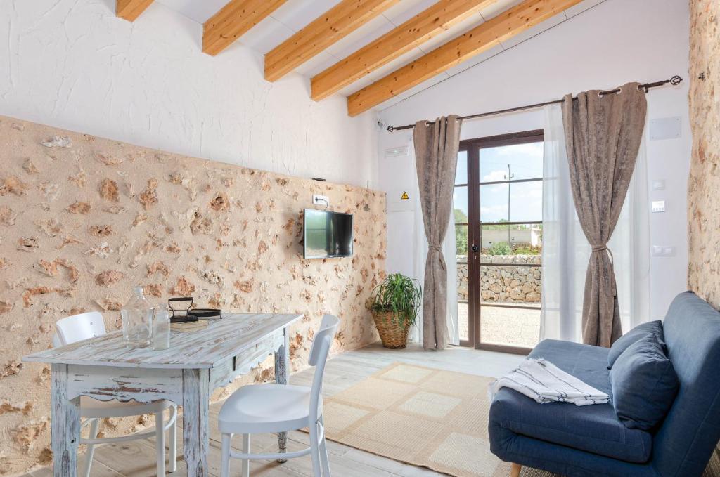 ein Wohnzimmer mit einem Tisch und einem blauen Sofa in der Unterkunft Cal Tio 2 Agroturismo YourHouse in Costitx