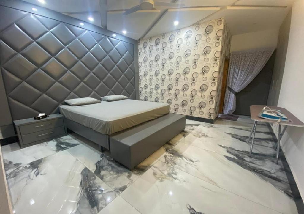 sypialnia z łóżkiem i stołem w obiekcie The Bahria Town Hotel & Suites w mieście Lahaur