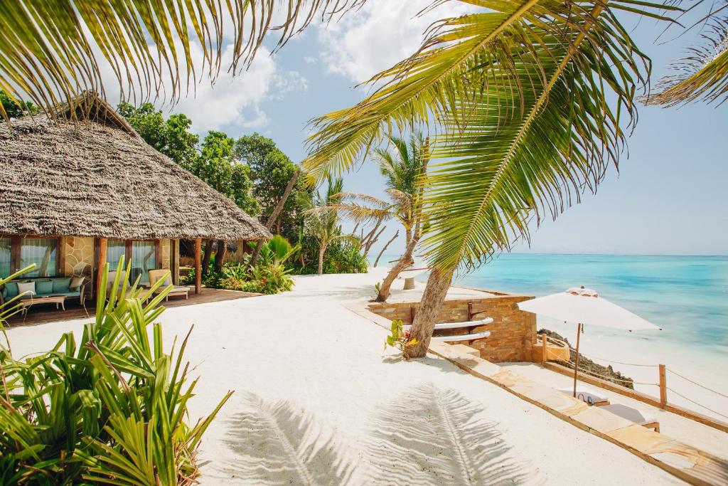 een resort met een strand en de oceaan bij Tulia Zanzibar Unique Beach Resort in Pongwe