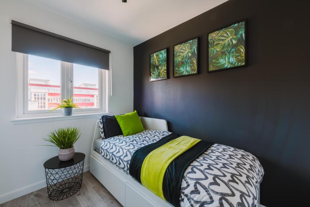 格拉斯哥的住宿－Emirates ApartHOUSE，一间卧室设有一张床和两个窗户。