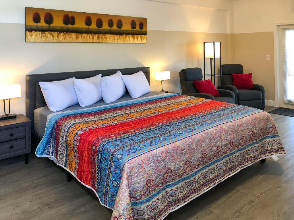 sypialnia z dużym łóżkiem i kolorowym kocem w obiekcie Star Apartments w mieście Fort Myers