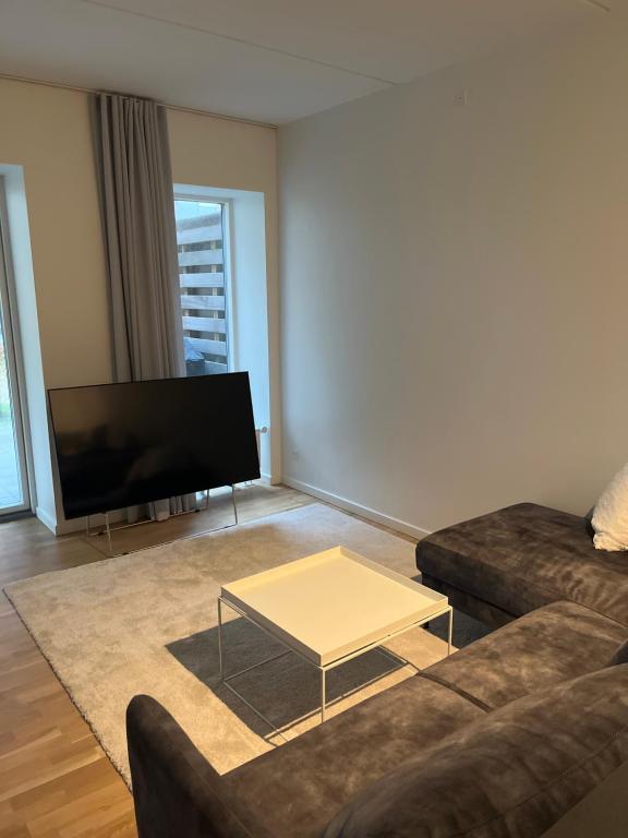 a living room with a couch and a coffee table at Charming Aalborg Apartment With parking in Aalborg