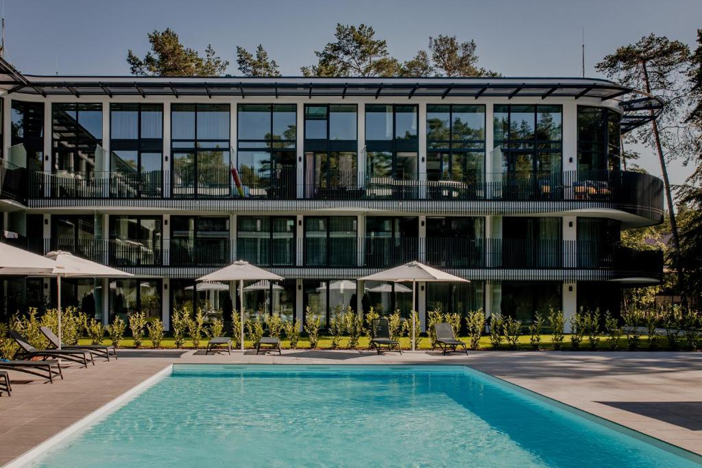 un bâtiment avec une piscine en face d'un bâtiment dans l'établissement Bursztynowe Resort&SPA Stegna, à Stegna