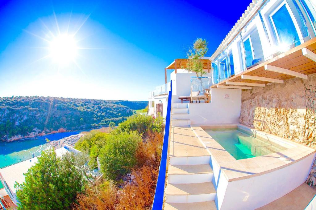 a villa with a swimming pool and a house at Seafront Villa Bellavista with heated pool in Cala en Porter