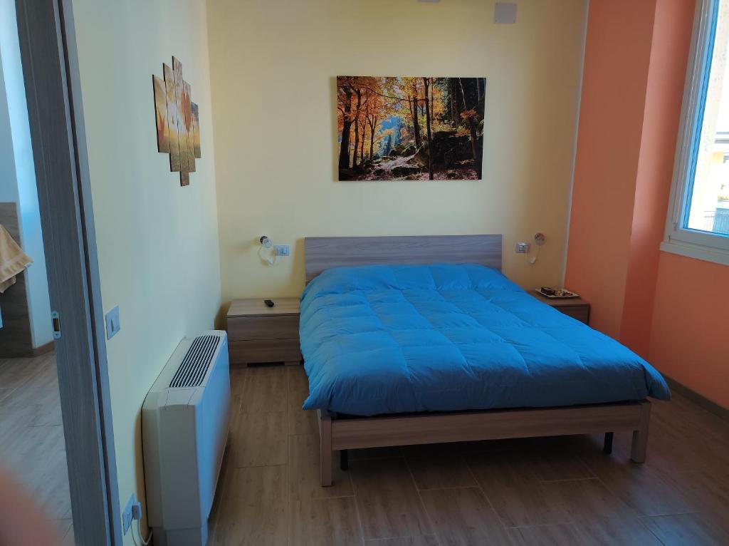 1 dormitorio con 1 cama azul y TV en Villa ARA blu, en Canegrate