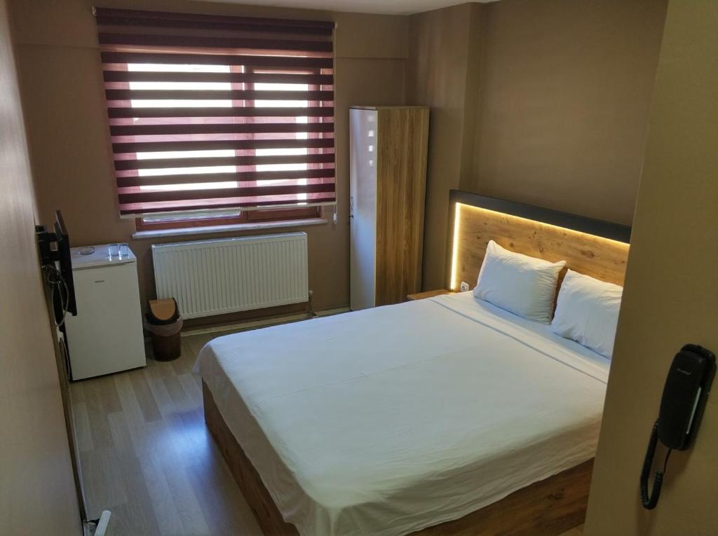 a bedroom with a large white bed with a window at ONKA OTEL in Zonguldak