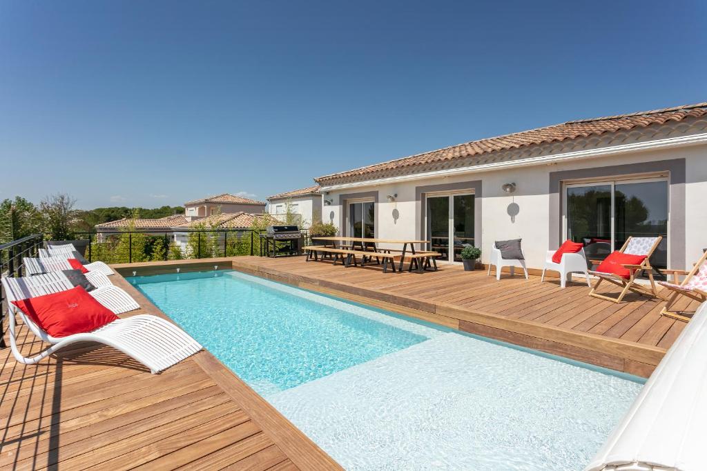 ein Haus mit einem Pool und einer Terrasse in der Unterkunft Villa Le Golf St Thomas 19 pers in Béziers