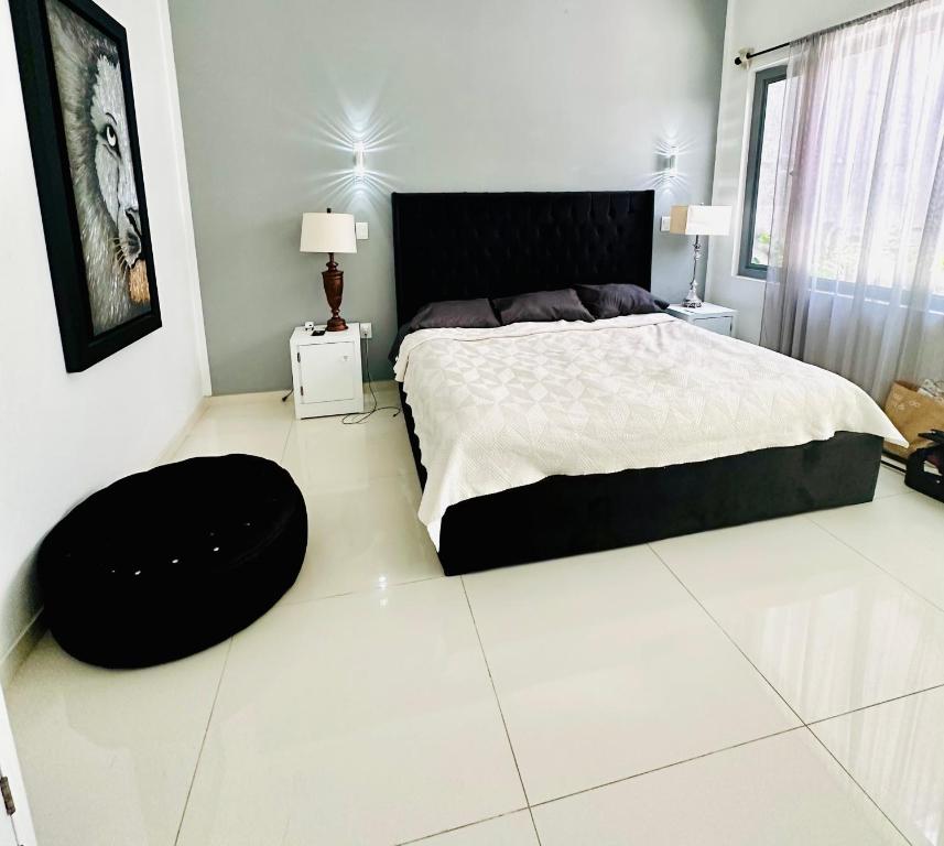 a bedroom with a large bed with a black headboard at Casa del Diseño in Uruapan del Progreso