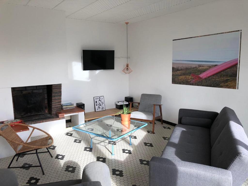 a living room with a couch and a table at Maison avec Jardin près des Plages in Le Bernard